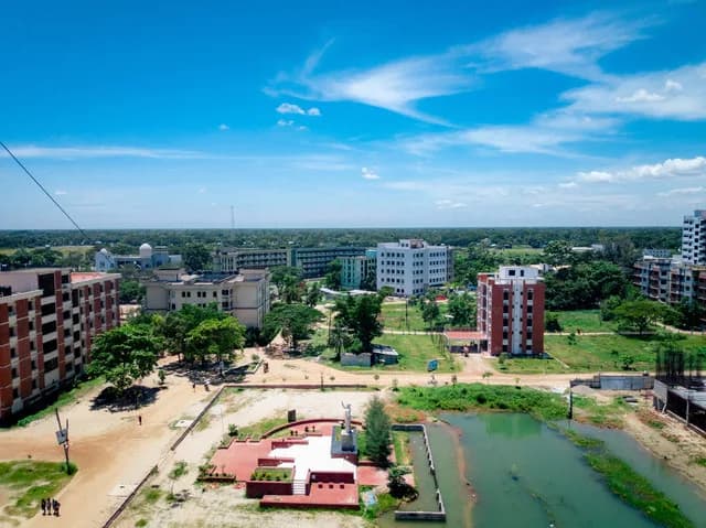 Aerial view of JKKNIU campus buildings, green spaces, and a pond